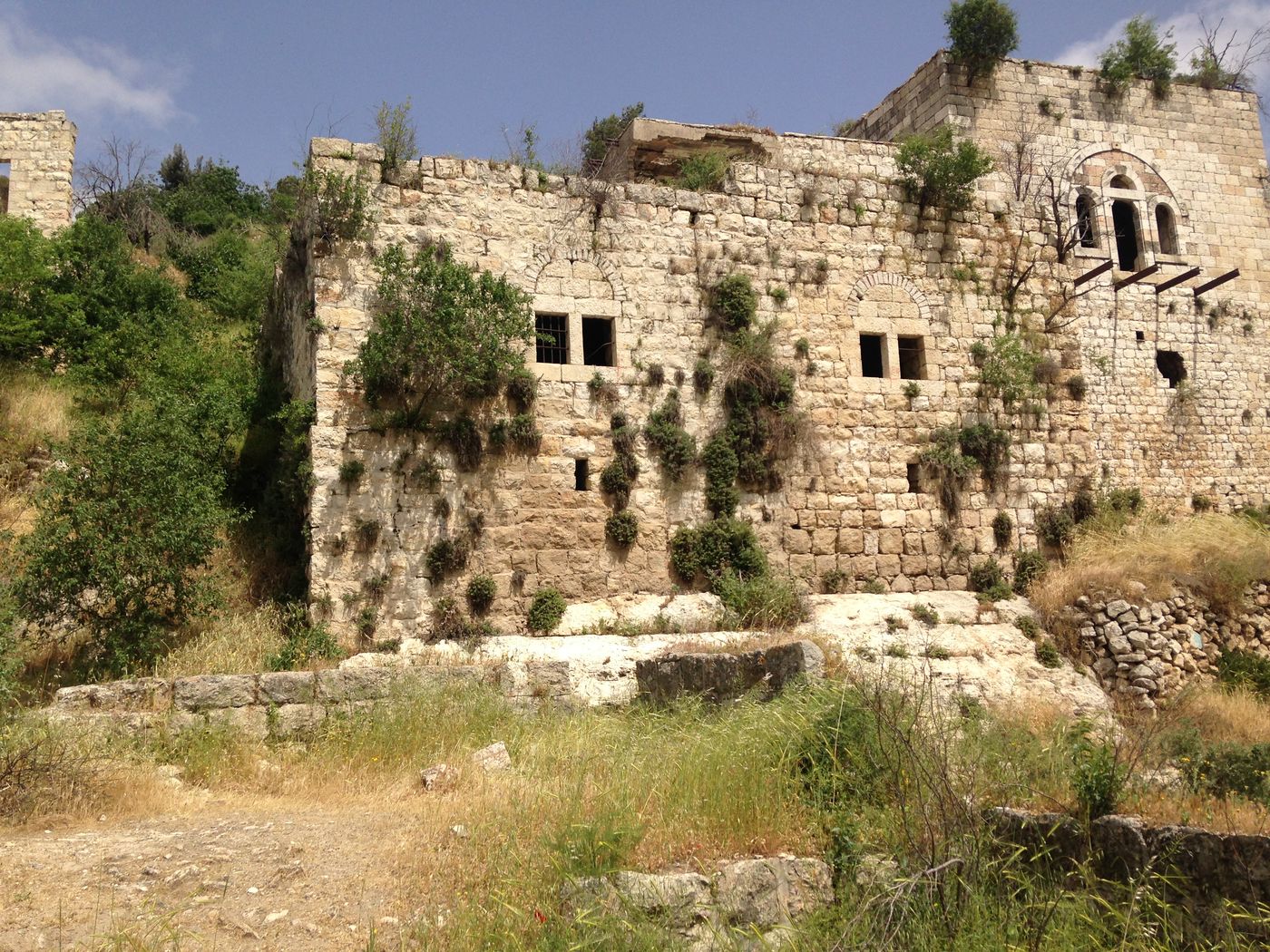 A large multi-storey stone house at Ein Lifta on 23 April 2017, with an arched window on its upper floor, under a blue sky.